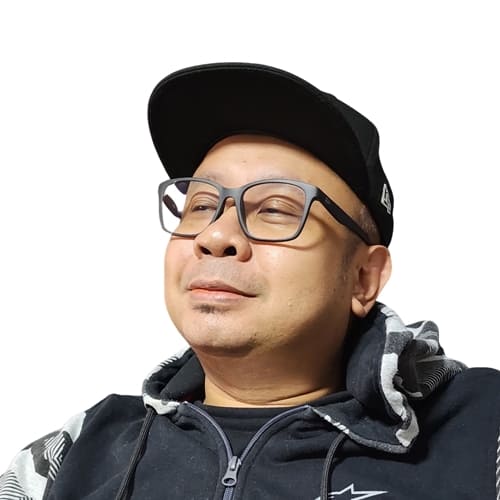 Man wearing a black cap and glasses with a neutral background
