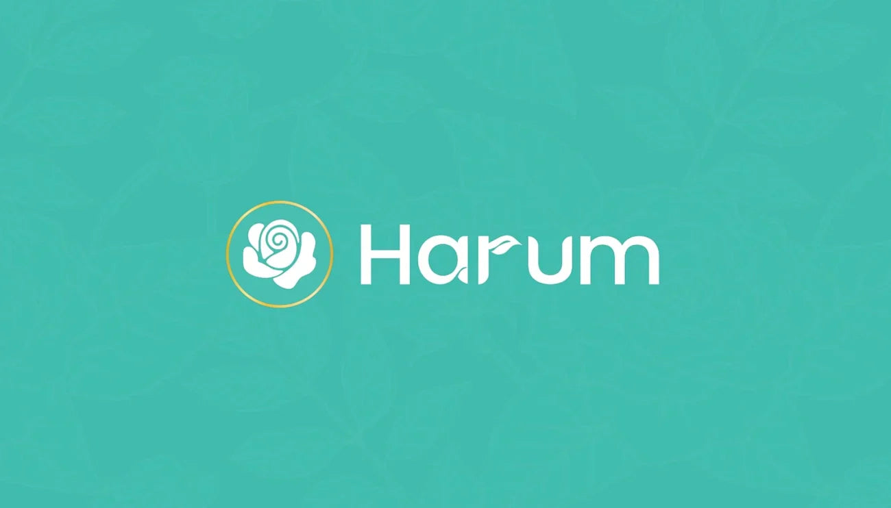 Harum brand logo featuring a white stylized rose icon enclosed in a gold circle, followed by the word 'Harum' in white sans-serif typography with a small leaf detail on the letter 'u', set against a teal background with a faint floral pattern.