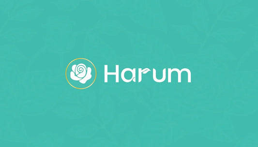 Harum brand logo featuring a white stylized rose icon enclosed in a gold circle, followed by the word 'Harum' in white sans-serif typography with a small leaf detail on the letter 'u', set against a teal background with a faint floral pattern.
