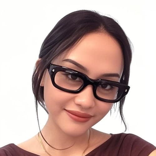 Woman wearing black glasses with a plain background
