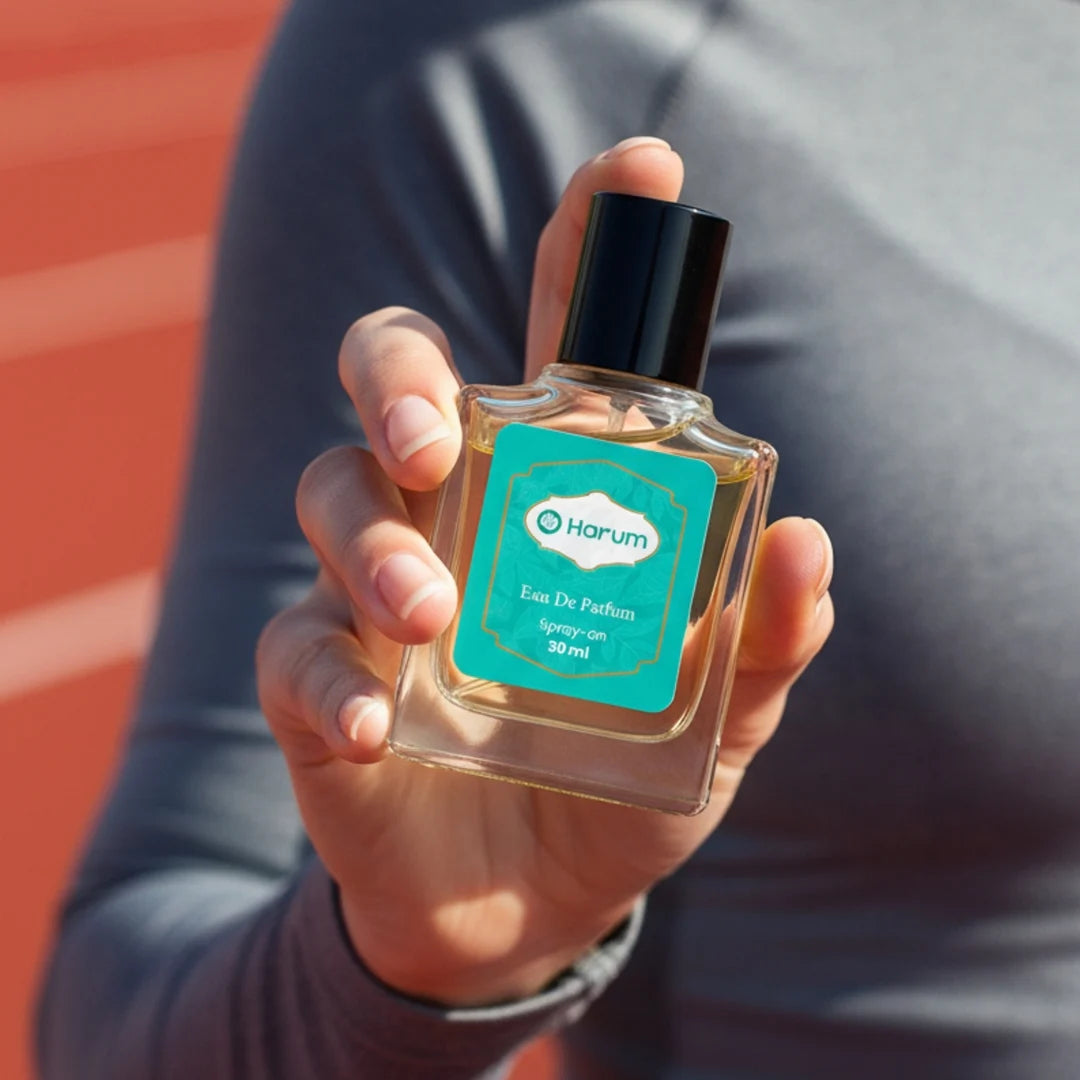 Hand holding Harum 30ml Eau De Parfum bottle with teal label on running track background