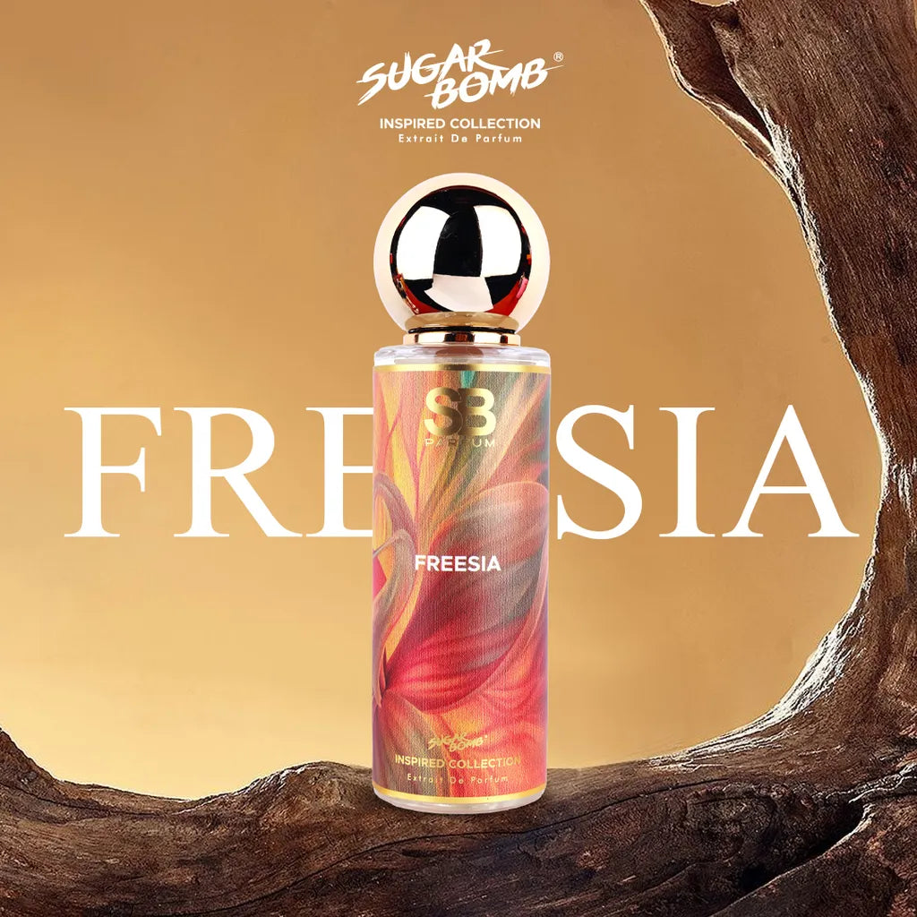 SugarBomb Freesia Extrait De Parfum from the Inspired Collection, a fresh fruity-floral fragrance inspired by Jo Malone English Pear & Freesia, framed by a rustic wooden arch.