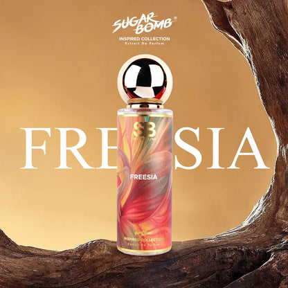 SugarBomb Freesia Extrait De Parfum from the Inspired Collection, a fresh fruity-floral fragrance inspired by Jo Malone English Pear & Freesia, framed by a rustic wooden arch.