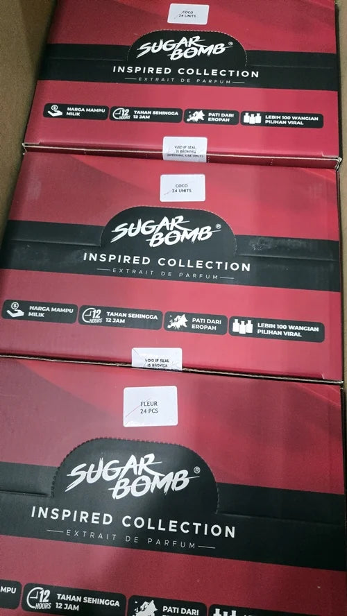 Three red and black bulk boxes of SugarBomb Inspired Collection Extrait De Parfum, labeled for Coco and Fleur scents.