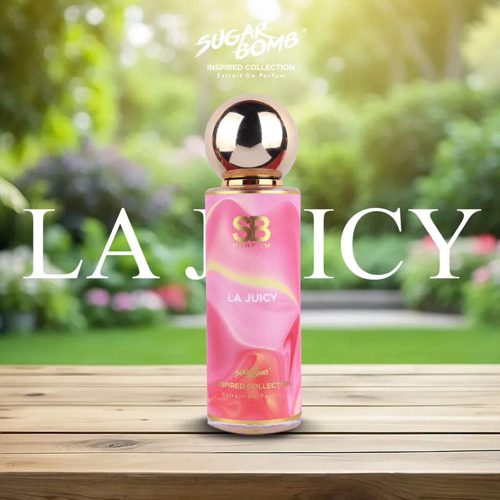 SugarBomb La Juicy Extrait De Parfum from the Inspired Collection, a sweet floral fragrance inspired by Juicy Couture Viva La Juicy, placed on a wooden table in a sunny garden.
