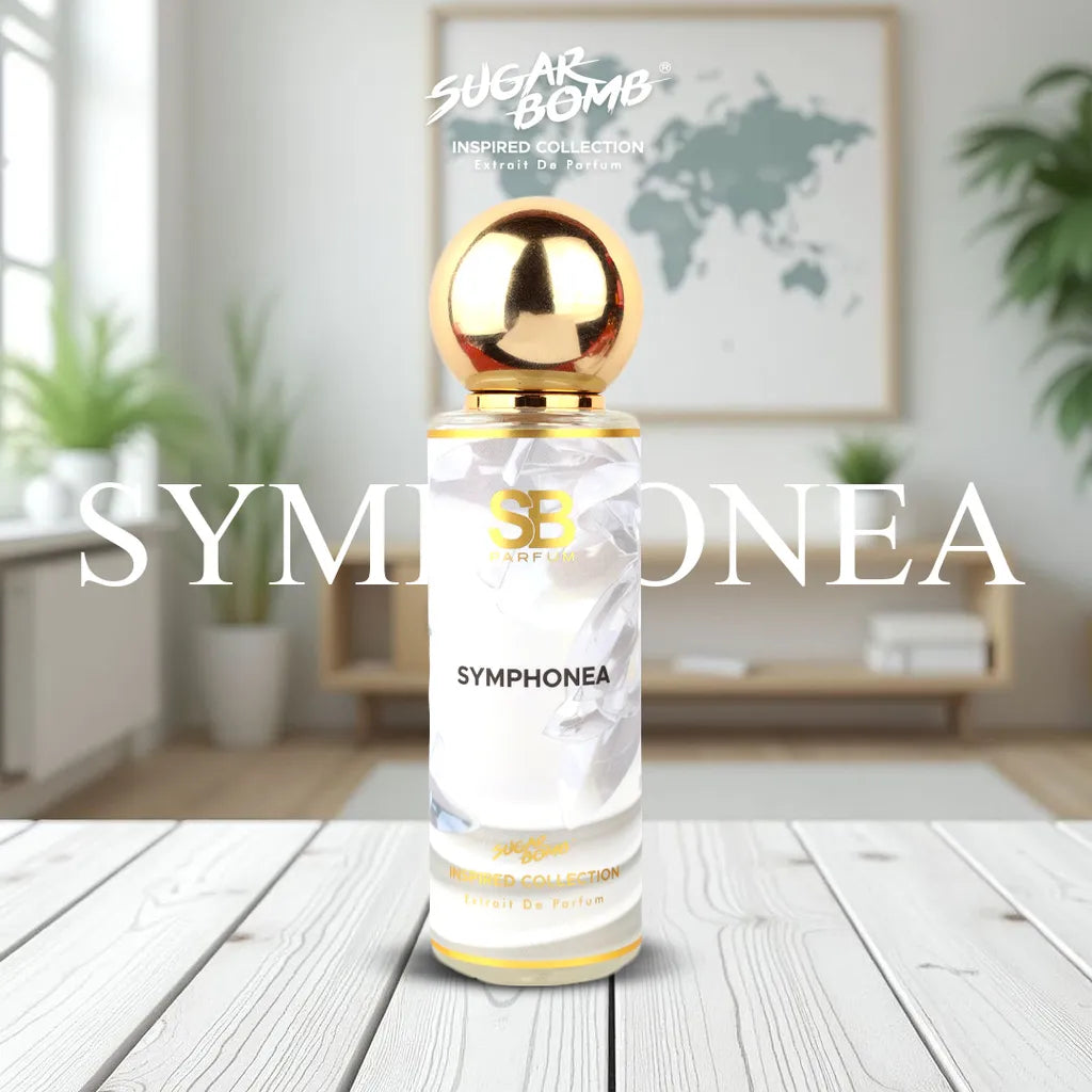 SugarBomb Symphonea Extrait De Parfum bottle standing vertically on a light-colored wooden table. The perfume bottle features a round gold cap and a white and grey patterned label with gold lettering. The text "SYMPONEA" is overlaid across the middle of the image in large white serif font. The background is a softly blurred, modern living room interior featuring indoor plants and a framed world map on the wall.