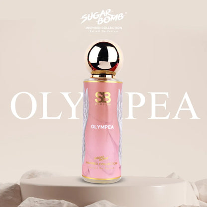 SugarBomb Olympea Extrait De Parfum from the Inspired Collection, a salted vanilla and amber women's fragrance inspired by Paco Rabanne Olympéa, featuring a pink bottle with white angel wing graphics standing on a cream pedestal surrounded by soft white stones.