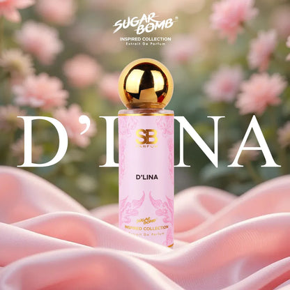 SugarBomb D'Lina Extrait De Parfum from the Inspired Collection, an opulent Turkish rose and litchi fragrance inspired by Parfums de Marly Delina, showcasing a pink bottle on a white column pedestal surrounded by full pink roses.